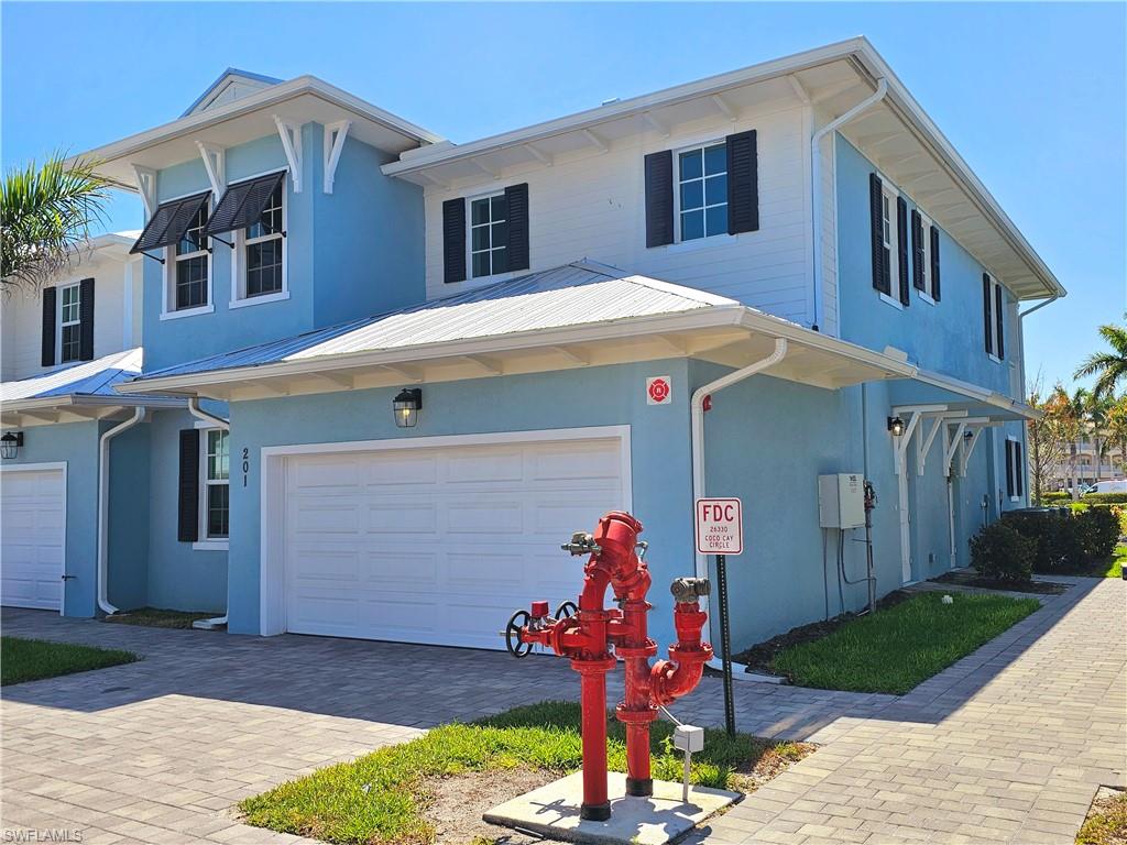 View of front of property featuring an attached garage, stucco siding, and driveway