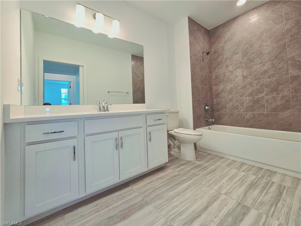 Bathroom featuring toilet, tub / shower combination, and vanity