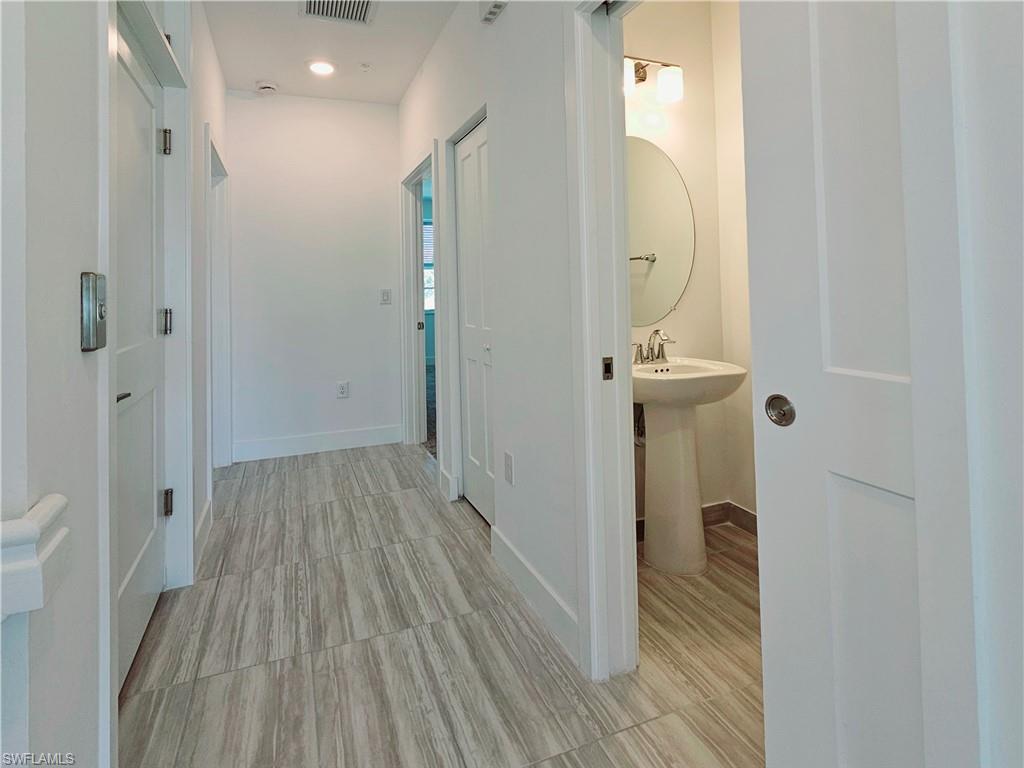 Hall with baseboards and a sink