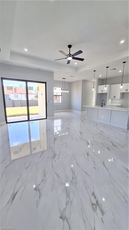 Kitchen featuring an island with sink, stainless steel appliances, open floor plan, white cabinets, and light marble finish floors