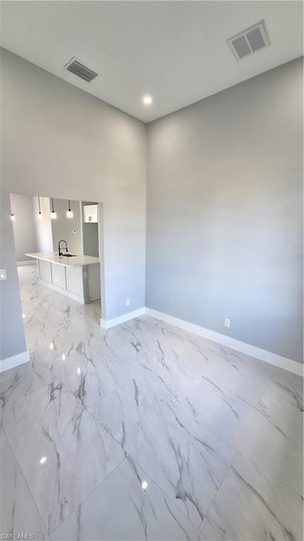 Full bathroom featuring a shower stall, double vanity, and light marble finish floors
