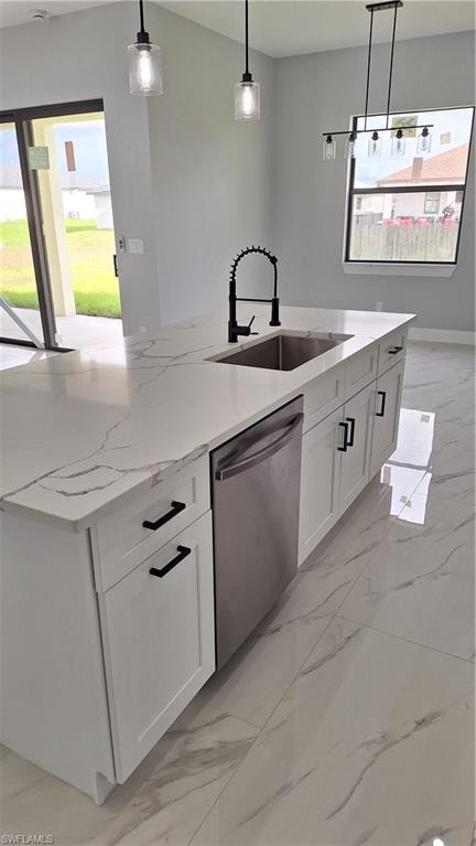 Kitchen with stainless steel appliances, light stone counters, pendant lighting, an island with sink, and light marble finish floors