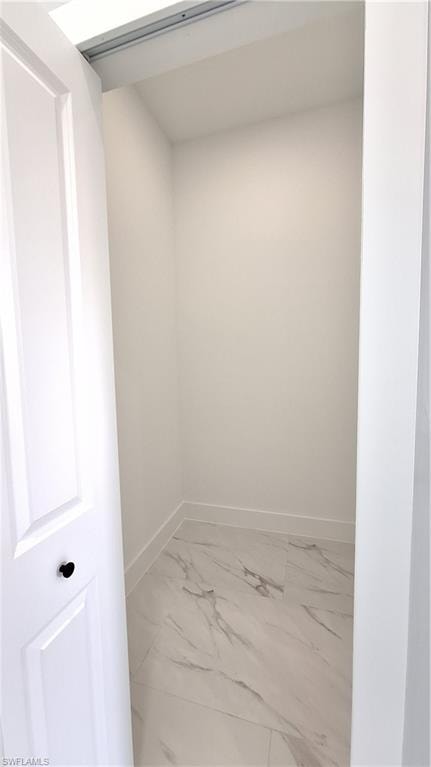 Laundry area featuring light marble finish floors, cabinet space, hookup for a washing machine, and hookup for an electric dryer