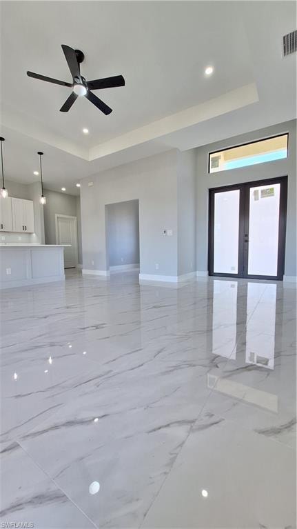 Kitchen featuring appliances with stainless steel finishes, white cabinetry, decorative light fixtures, a kitchen island with sink, and light marble finish floors