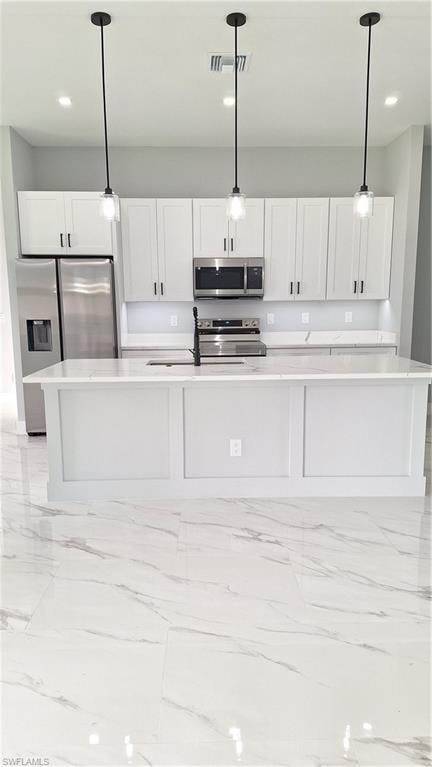 Kitchen with stainless steel appliances, light stone countertops, white cabinetry, and light marble finish floors