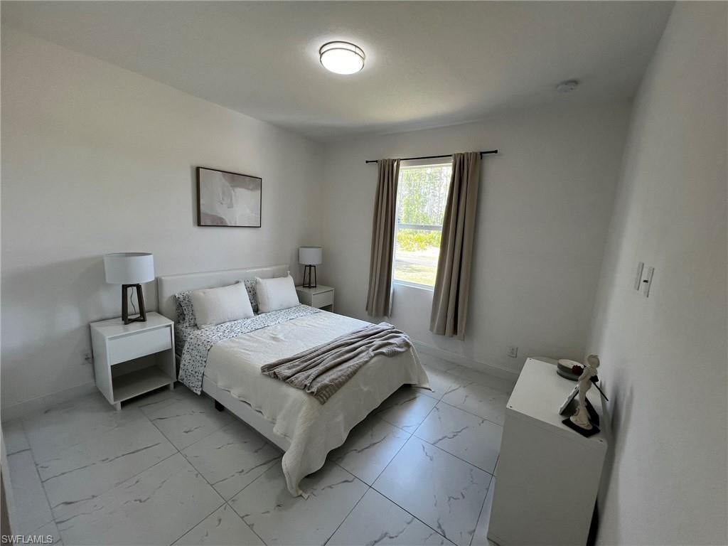 Bedroom with marble finish floor and baseboards