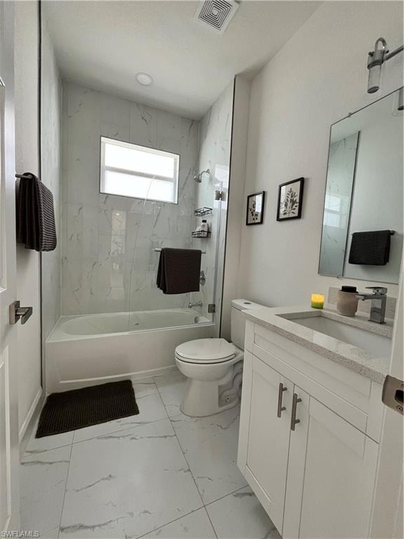 Full bath with vanity, shower / bathtub combination, and light marble finish flooring