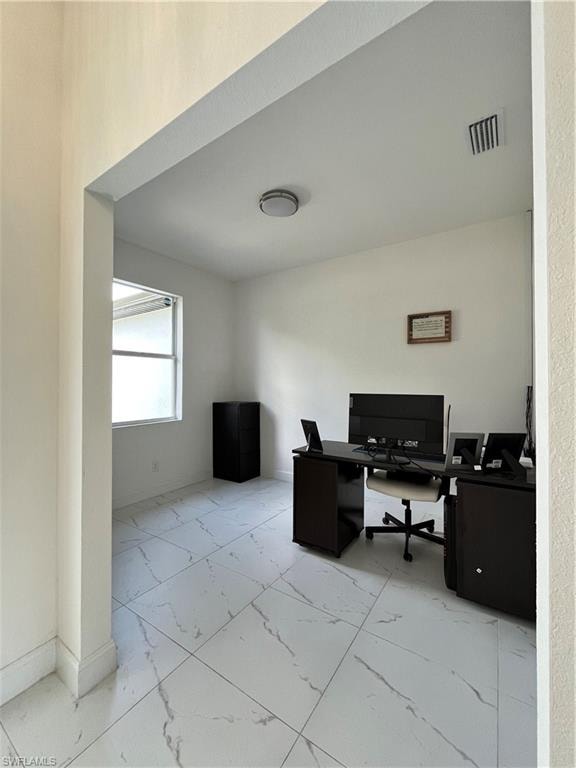 Office area with marble finish floor, baseboards, and visible vents