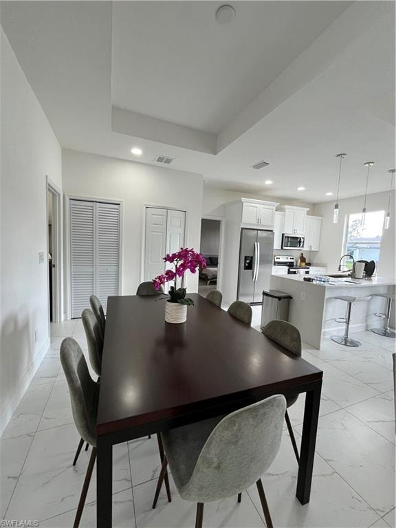 Dining room featuring marble finish floor, baseboards, visible vents, and recessed lighting