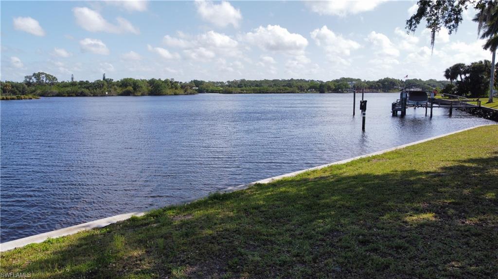 Water view featuring boat lift and a dock