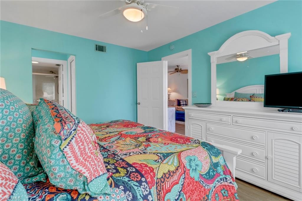 Bedroom with visible vents, a ceiling fan, and wood finished floors