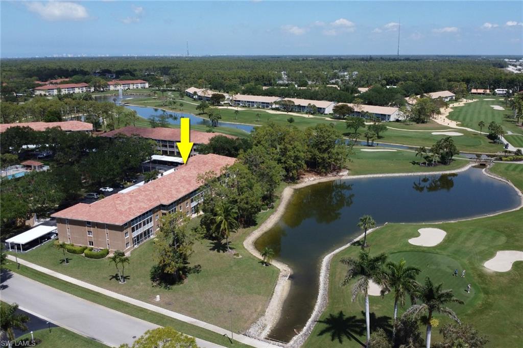 Drone / aerial view with golf course view and a water view