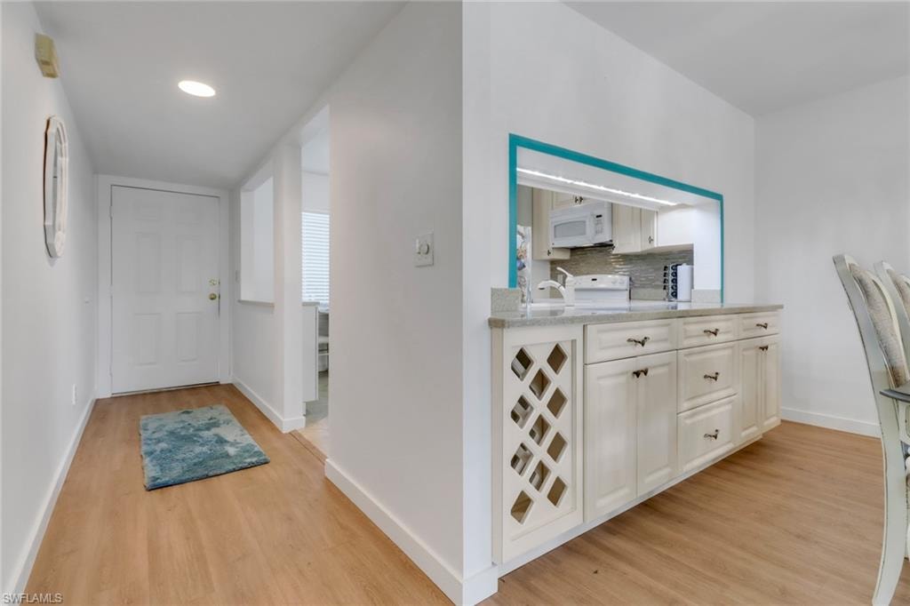 Hall with baseboards, recessed lighting, and light wood-style floors