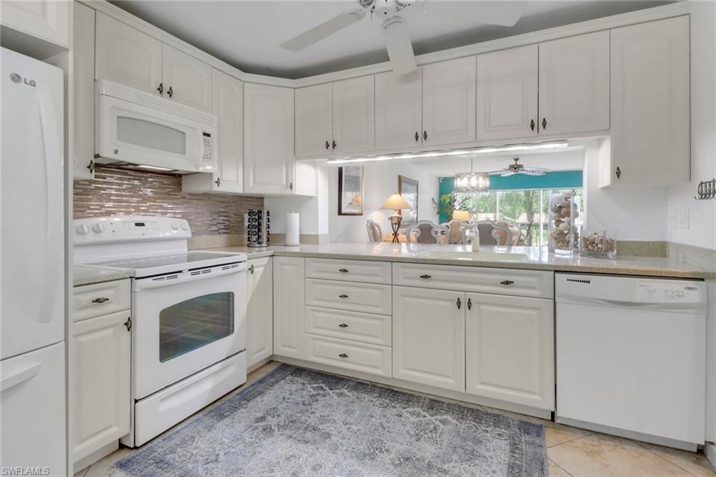 Kitchen with white cabinets, a sink, a ceiling fan, and white appliances