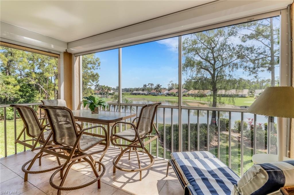 Sunroom with tile patterned floors and a water view