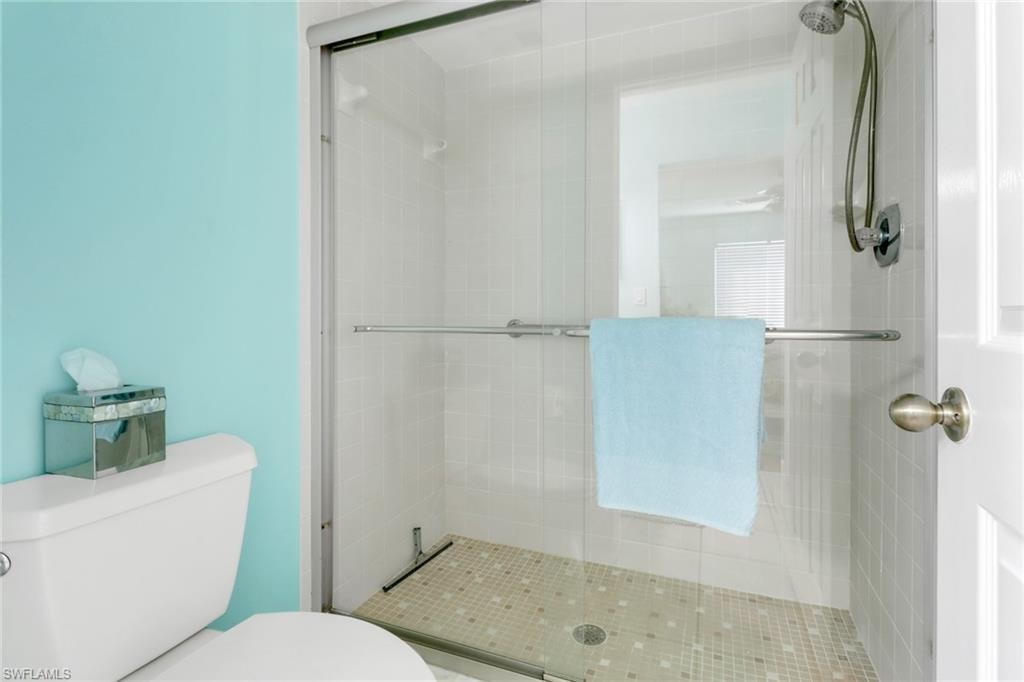 Full bathroom featuring toilet and a stall shower