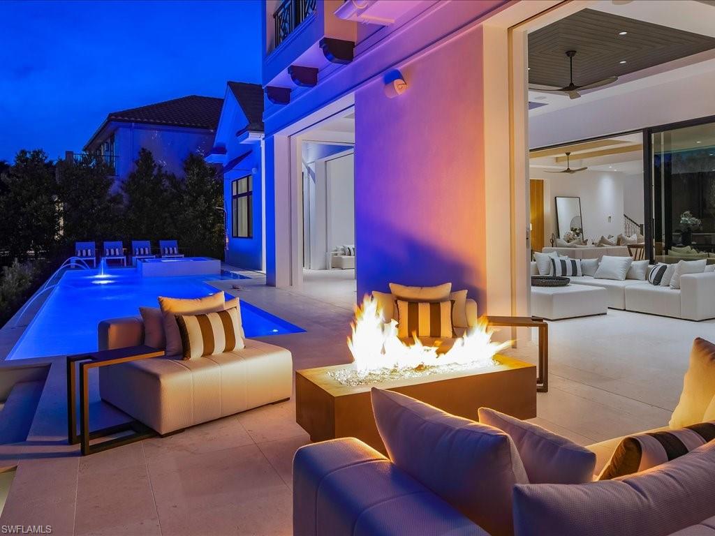 View of pool featuring a patio and an outdoor living space with a fire pit