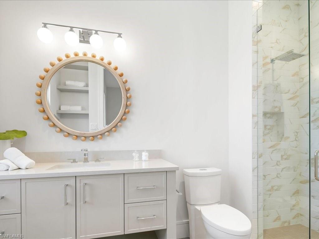 Full bath featuring toilet, vanity, and a shower stall