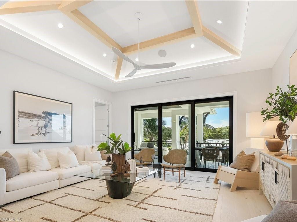 Living area with a ceiling fan, recessed lighting, beamed ceiling, and wood finished floors