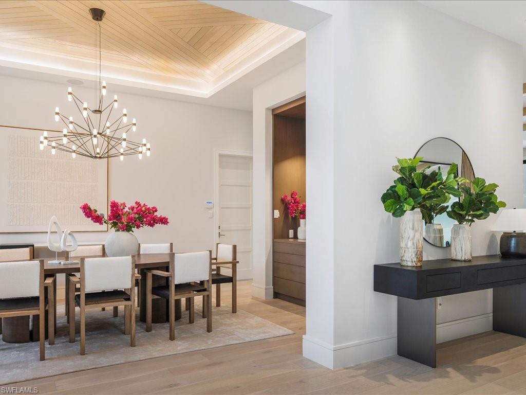 Dining space with wooden ceiling, a raised ceiling, wood finished floors, baseboards, and an inviting chandelier