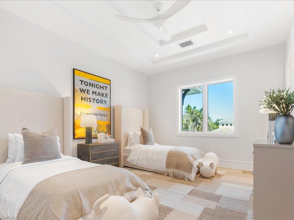 Bedroom featuring a tray ceiling, recessed lighting, baseboards, a skylight, and visible vents