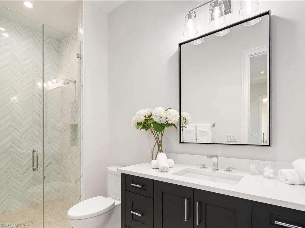 Full bath featuring toilet, vanity, and a shower stall