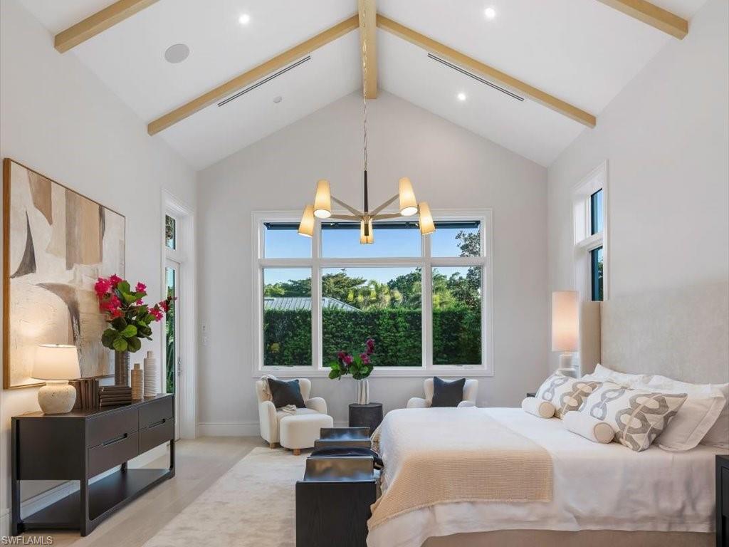 Bedroom featuring high vaulted ceiling, baseboards, a chandelier, beam ceiling, and visible vents