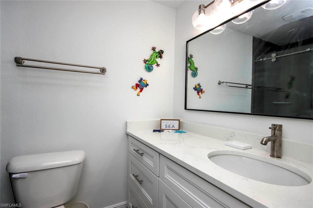 Full bathroom with toilet, a shower, and vanity