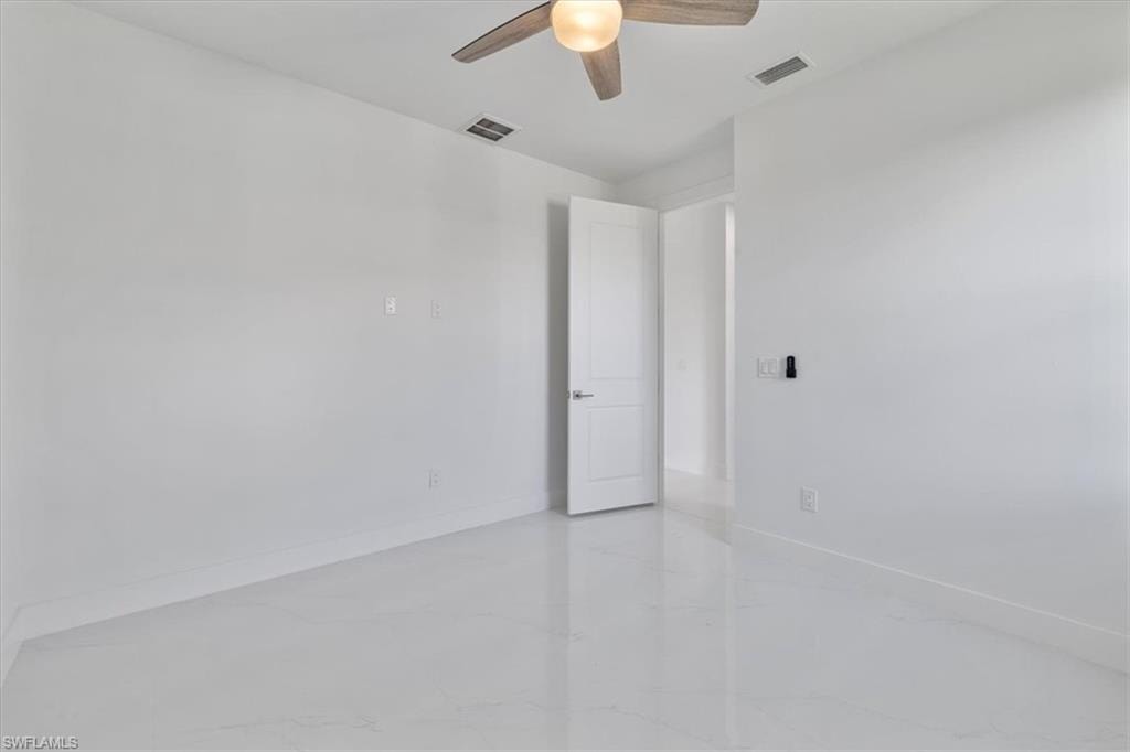 Spare room with baseboards, visible vents, and ceiling fan