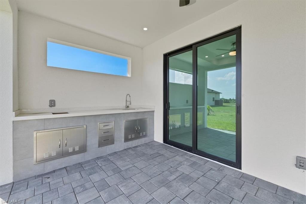View of patio with area for grilling and a sink