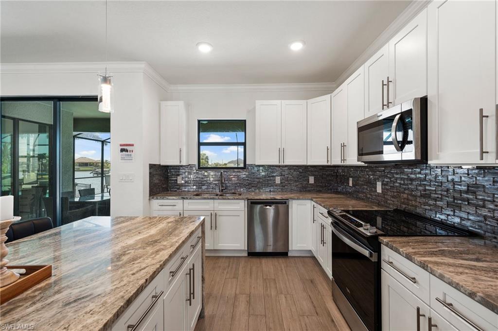 Kitchen with a sink, ornamental molding, plenty of natural light, and stainless steel appliances