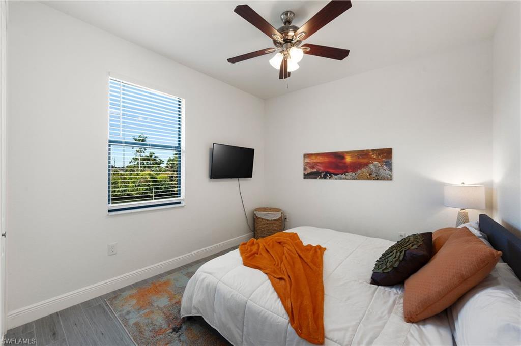 Bedroom featuring baseboards, a ceiling fan, and wood finished floors