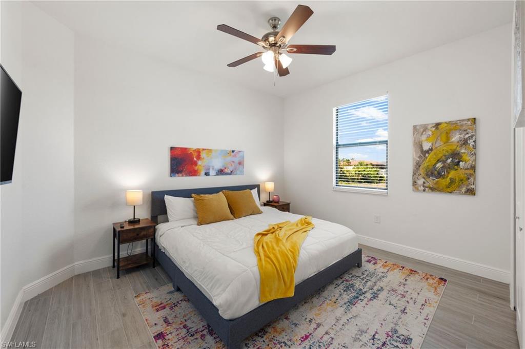 Bedroom with light wood finished floors, baseboards, and a ceiling fan