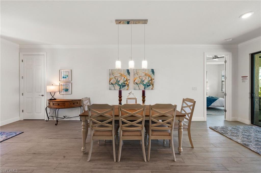 Dining room with ornamental molding, baseboards, and wood finished floors