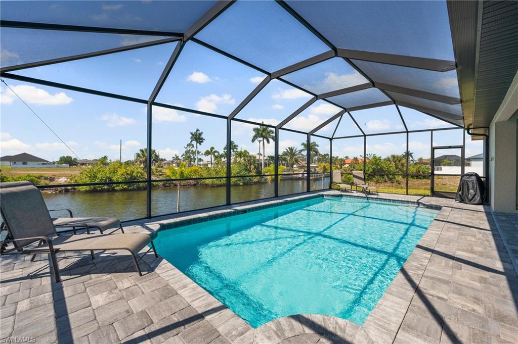 Outdoor pool featuring a water view, a patio area, and a lanai