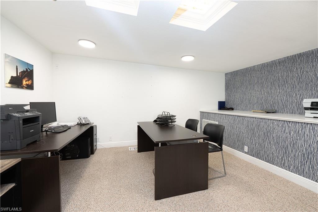 Office with a skylight, carpet, baseboards, and wallpapered walls