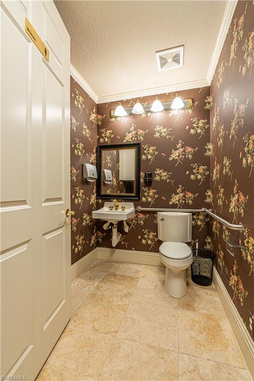 Half bath with a textured ceiling, wallpapered walls, and toilet
