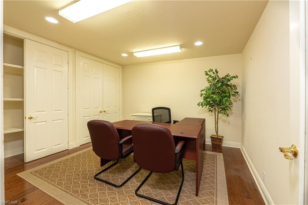 Home office featuring recessed lighting, baseboards, a textured ceiling, and wood finished floors