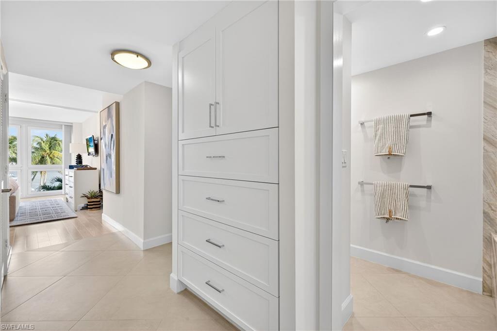Hallway to bathroom with 2 walk in closets and storage on opposite side