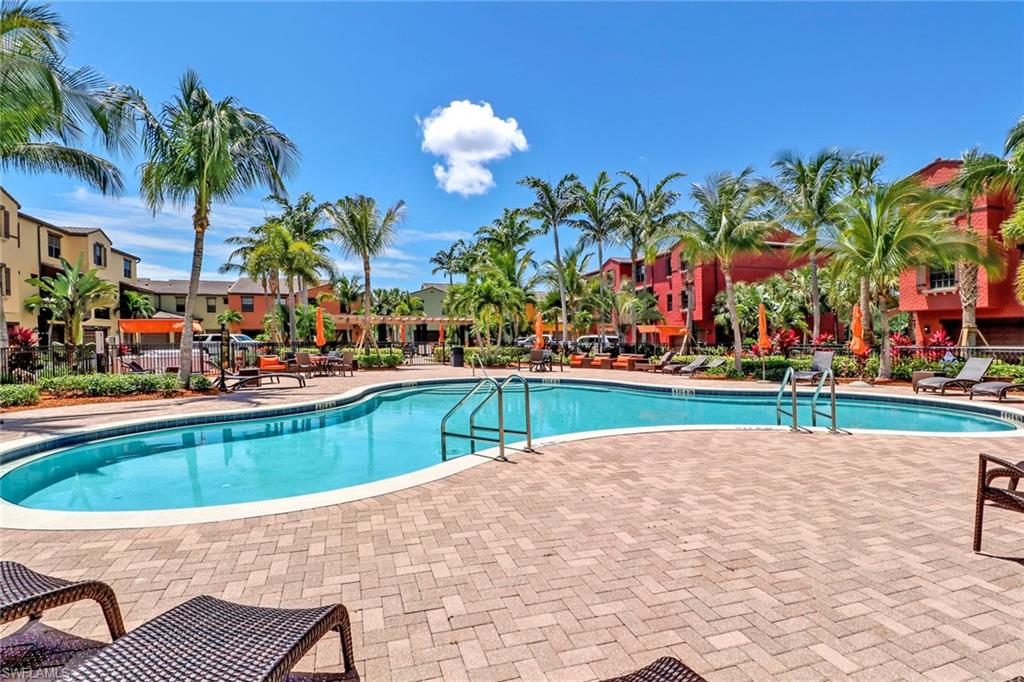 Community pool with a patio area and fence