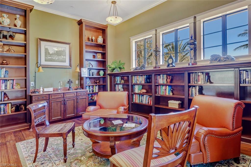 Living area featuring crown molding, wood finished floors, and a healthy amount of sunlight