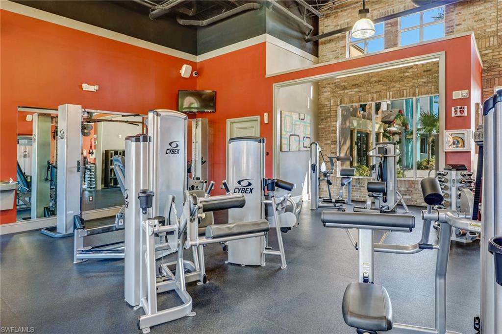 Workout area featuring brick wall and a high ceiling