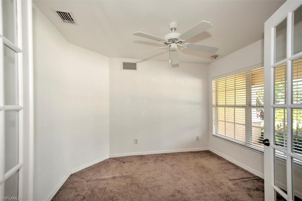 Den with ceiling fan and french double doors