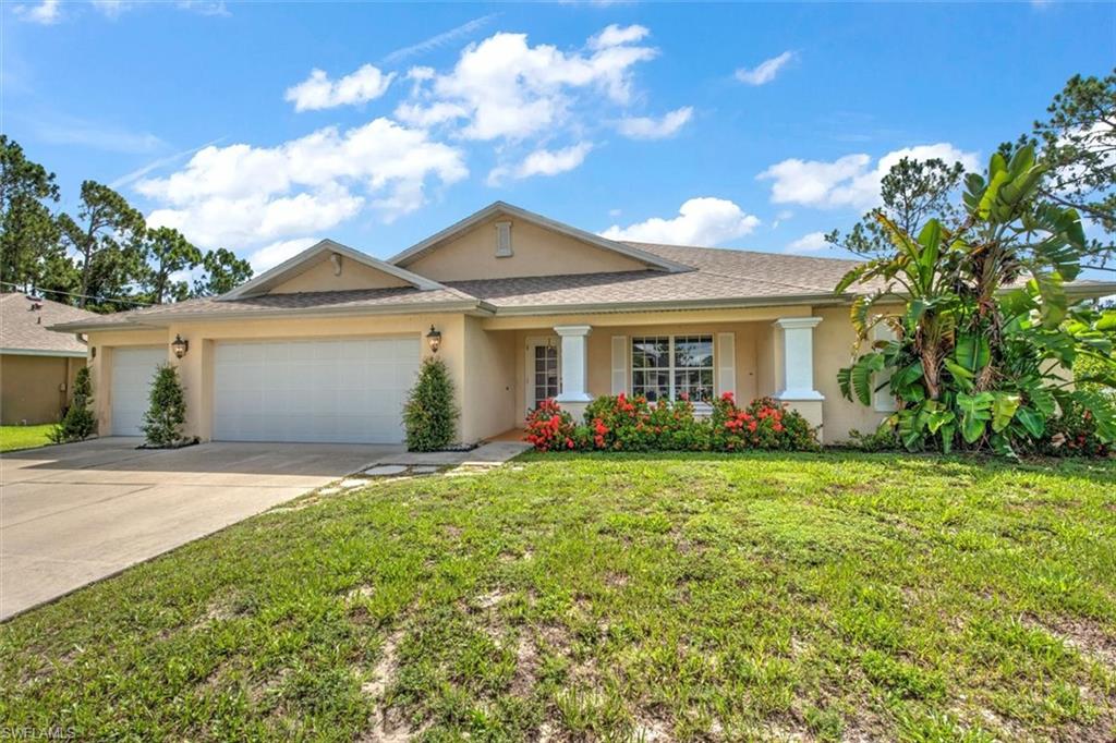 Single story home featuring a garage, covered patio and a front lawn