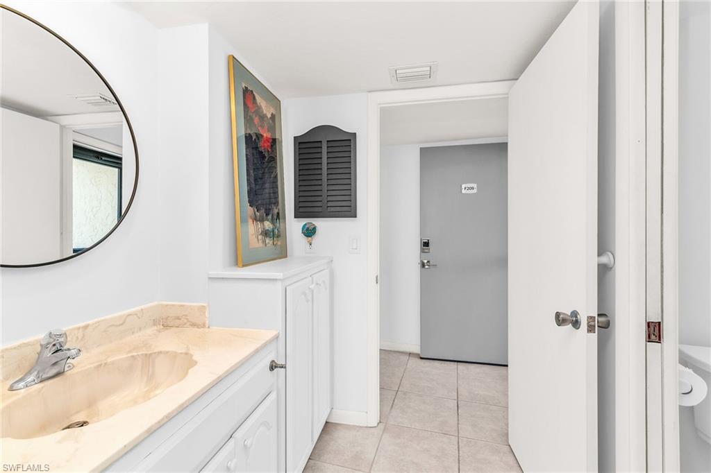 Bathroom with tile patterned flooring, vanity, visible vents, and baseboards