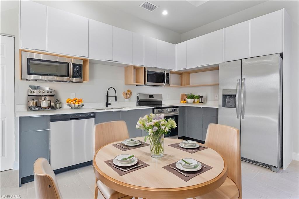 Kitchen featuring recessed lighting, light countertops, visible vents, stainless steel appliances, and a sink