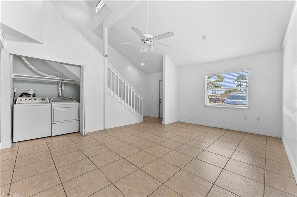 Unfurnished living room featuring separate washer and dryer, ceiling fan, lofted ceiling, and light tile patterned floors