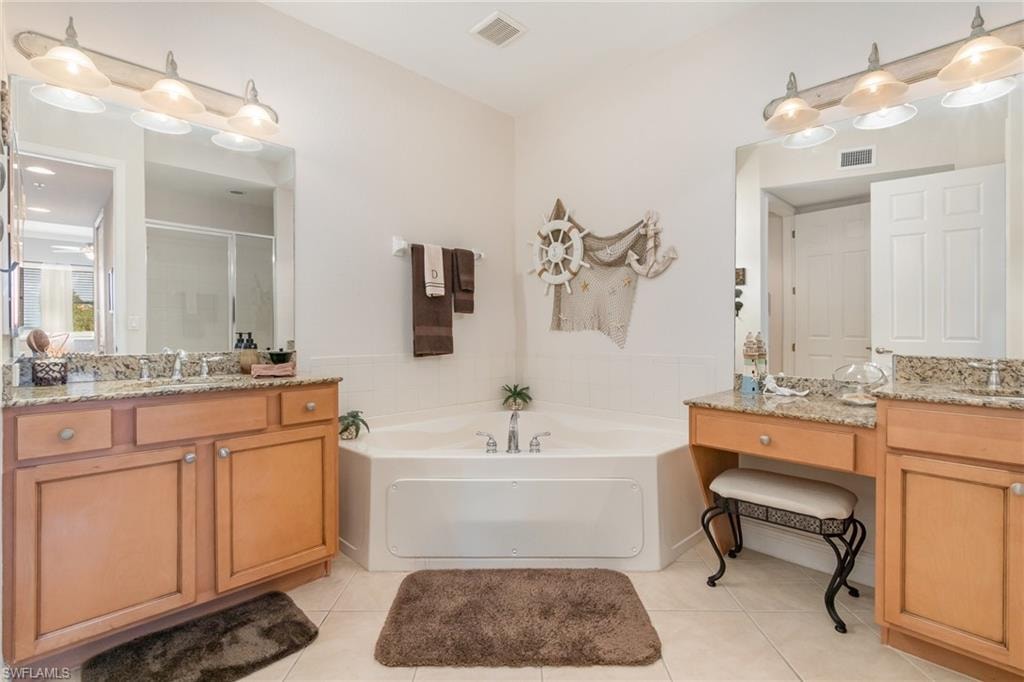Full bathroom featuring tile patterned floors, visible vents, a sink, and a shower stall