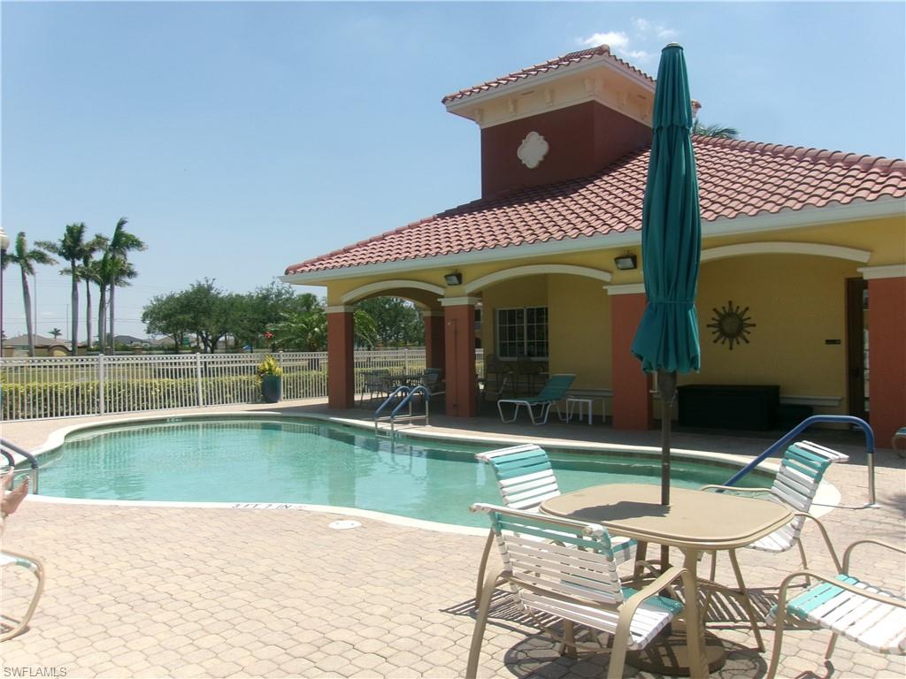 Community pool with fence and a patio area