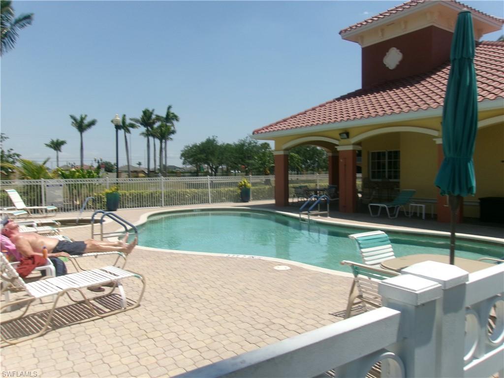 Community pool featuring fence and a patio area